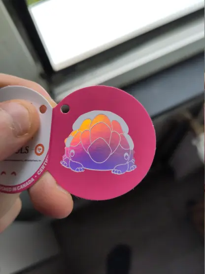 Label for the crystal lizard having a stylized drawing of it with holographic foil on it.
Its very cute.
