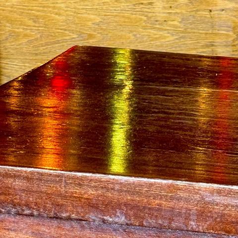 Reflection of some nearby colored lights on a wood table