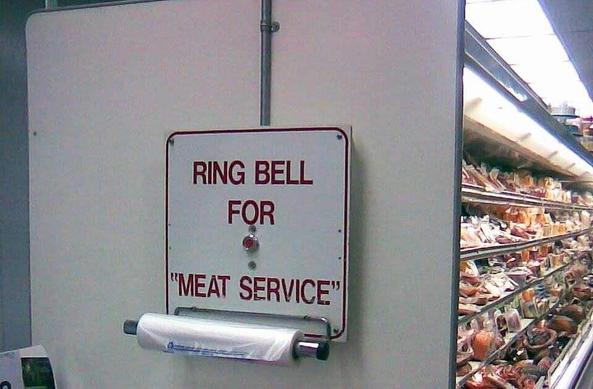 sign outside meat aisle at a grocery store that says: ring bell for "meat service"