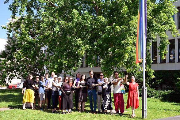 Vertreter*innen des Queer Staff Networks, Vizepräsidentin Prof. Blechinger-Talcott, Diversitäts- und Antidiskriminierungsbeauftragte Carolin Loysa sowie viele weitere Allies beim Hissen der Inter*-Inclusive-Progress-Pride-Flagge vor dem Henry-Ford-Bau der Freien Universität Berlin.
Foto: Constanze Kaul