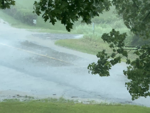 Water sprays across and up a road
