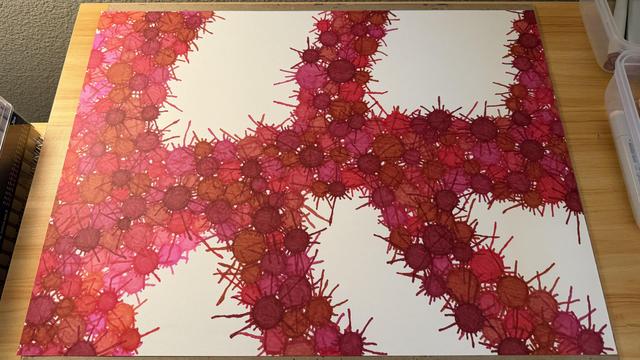 A branchlike structure composed of splattery circles in different shades of red and maroon, now starting to be covered with a layer of more circles of pinks, salmons, and light magentas