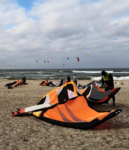 Surfer und Kites am Strand