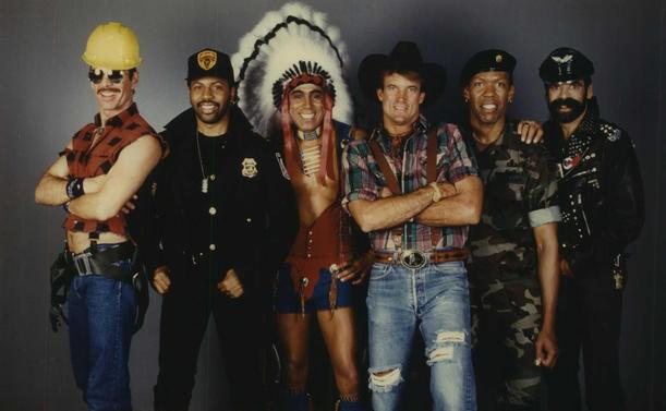 Photo of the original Village People line-up. each member was dressed as a character. From the left: a construction worker, a policeman (Willis), a Native American chief, a cowboy, a Marine, and a motorcyclist.