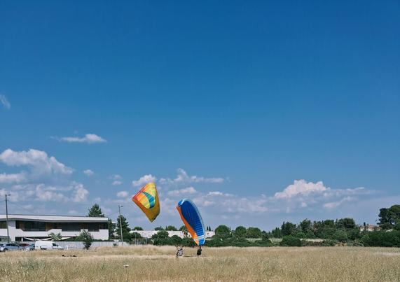 Deux personnes s'entraînant à gonfler leur voile de parapente