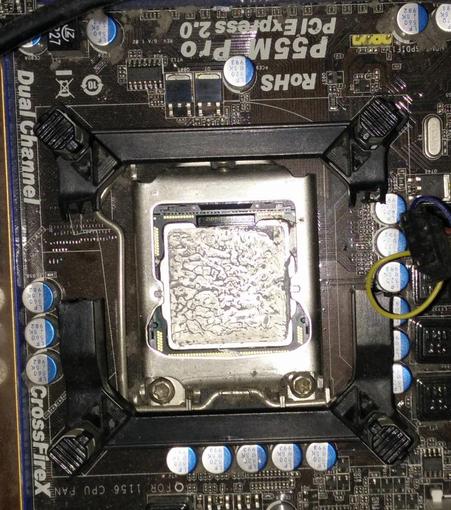 A cpu in it's motherboard, surrounded by the remains of it's fan mounting frame - with two big gaps in the side of it.