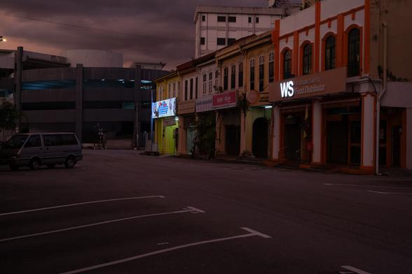 A street and car park in the purple light of sunset.
