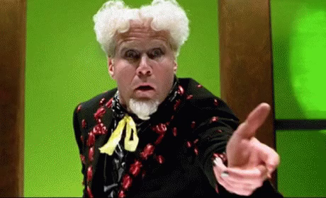 A man with outrageous white hair, and a flamboyant costume mouths the words, "It's beautiful!"