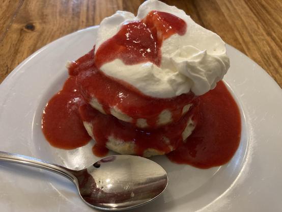 Homemade strawberry shortcake on a white plate on a rosewood dinner table