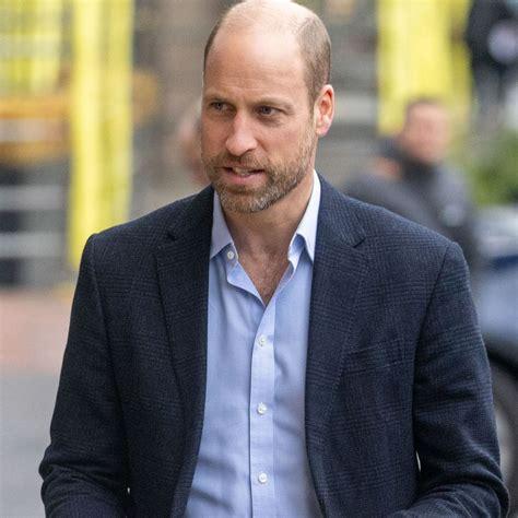 William casual zonder stropdas en bovenste knoopje los.
