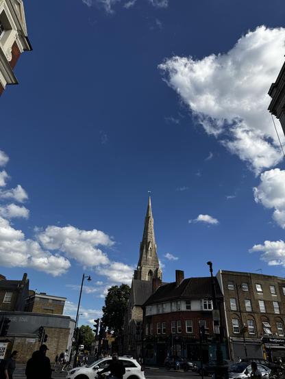 A church steeple against a blue sky with a few white clouds