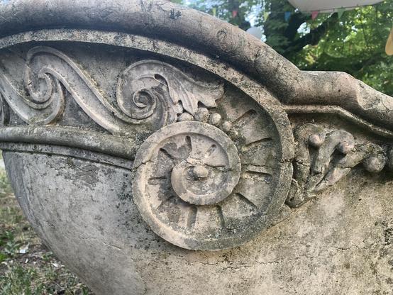 decorative swirl(s) on the corner of an outdoor, stone bathtub