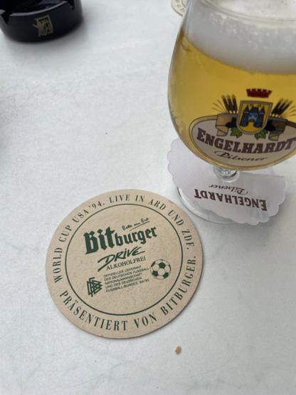 Bierdeckel neben Bierglas auf weißem Tisch, Aufdruck: World Cup USA ’94.