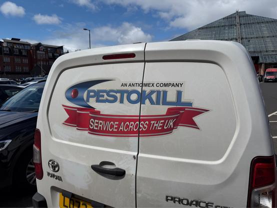a logo on the back of a white van for “Pestokill”, featuring some extremely 90s-looking graphic design with a shiny red sphere within a blue gradient swoosh. below it is a 3D rendering of a red banner reading “service across the UK”