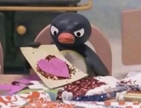 a very unimpressed pingu holding up a glittery collage