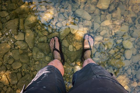 mes pieds en sandales dans l’eau, sur les galets