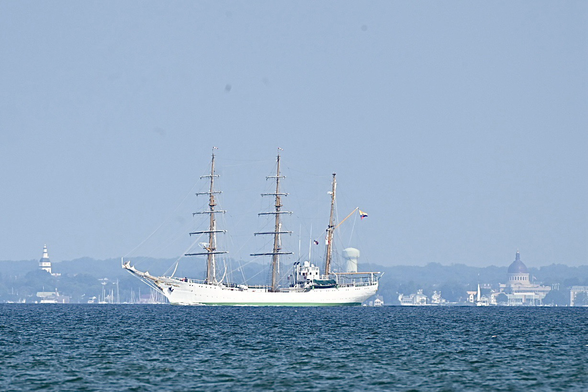 Tall ship sailing on the Chesapeake bay with the Annapolis skyline in the background.