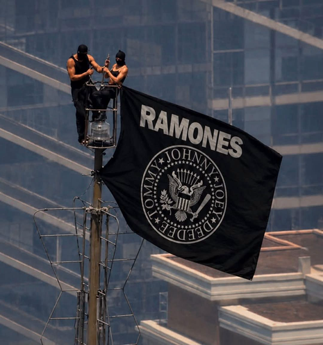 Two people who scaled the Empire State Building unfurl a banner that instead reads the Ramones
