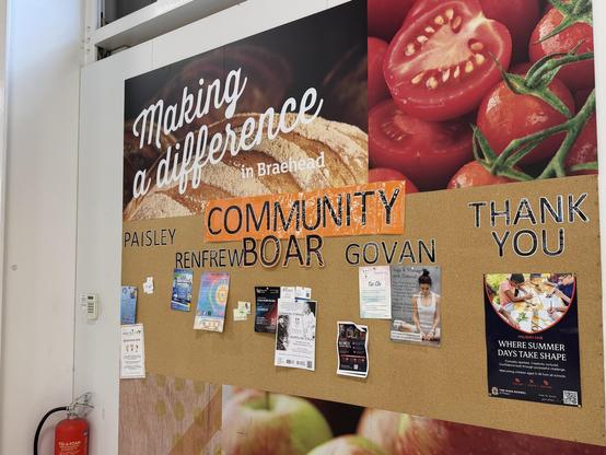 a board inside the entrance of a supermarket has various posters pinned to it, and individually-stuck letters reading “Community Boar. Paisley, Renfrew, Govan, Thank you”
there’s an obvious gap where the D in Board used to be