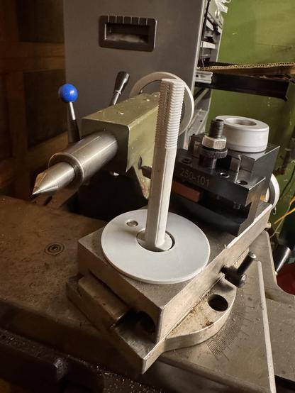 The top of a lathe compound looking back along the lathe towards the tail stock. It shows that a 3d printed stud and a 3d printed spacer ring has been installed in the top of the compound.