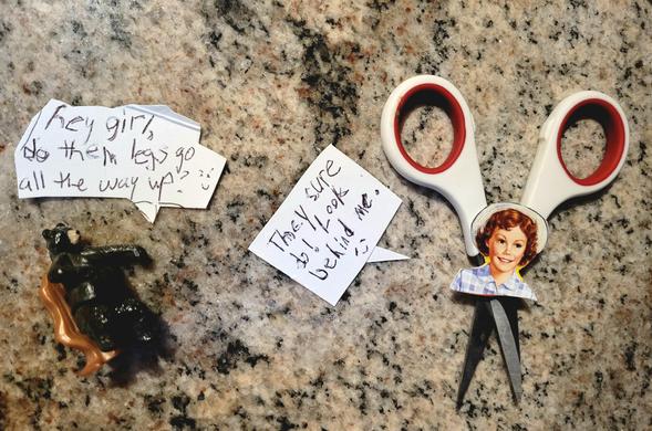 A scene set on gray and brown mottled stone countertop. On the left, a plastic black bear toy maybe an inch tall has a speech bubble that reads, "hey girl, do them legs go all the way up? 😛" On the right, a drawing of Little Debbie, with short red curls under a straw sun hat, is taped onto the pivot point of a small pair of scissors such that the small silver blades act as her legs and the white-and-red handles loom behind her like jet engines. Her speech bubble says, "They sure do! Look behind me! 😇"