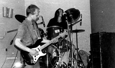 m0bi za perkusją na koncercie SKTC w Krakowie. Na pierwszym planie Kondzioł, gitarzysta