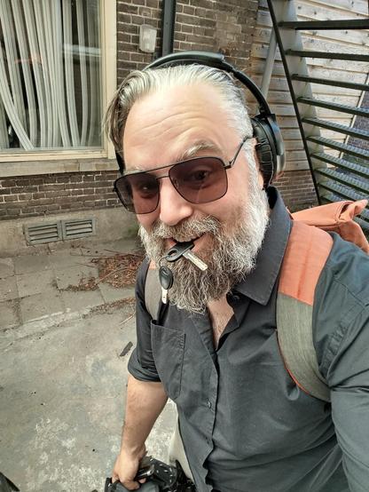 rushed selfie. Sunglasses on, key in my mouth, trying to grab something from my bicycle bags.