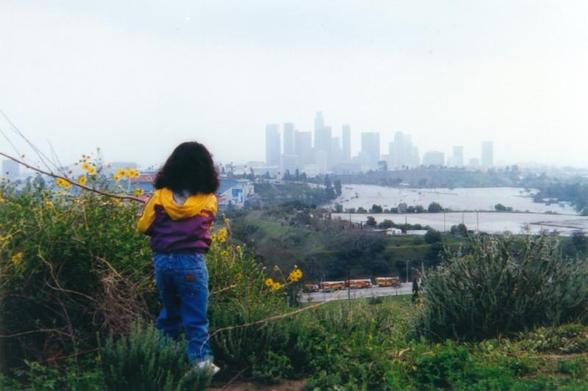 Cecilia takes in the view of Dodger Stadium and Downtown Los Angeles while playing in Elysian Park.
