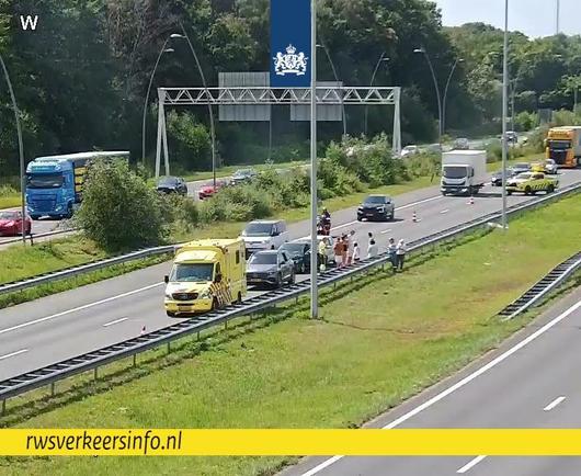 Brandweer en weginspecteur zijn aanwezig. Verkeer rijdt langs het ongeval.