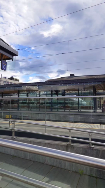 A video of a train platform and then the camera pans around and the platform extends to a pleasant waterside