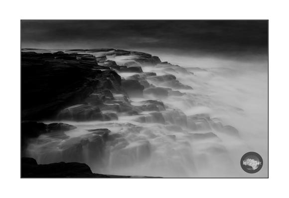 Waves on the rocks. Black and white. Long exposure.