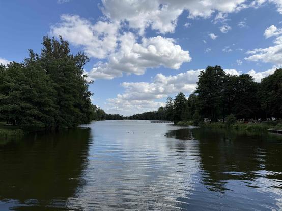 Photo of a lake. Water trees and blue sky.