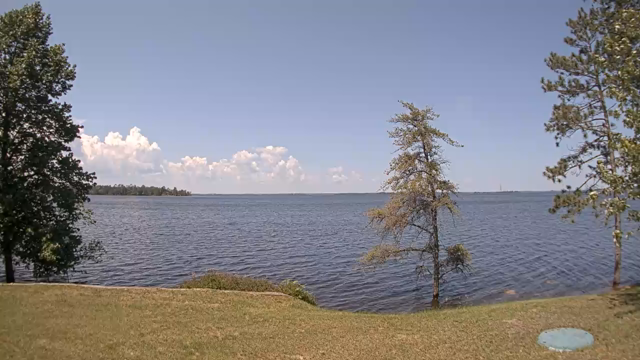 This webcam usually shows a large lake with a few trees in the foreground and the background. It's cloudy. It's 75ºF/24ºC.