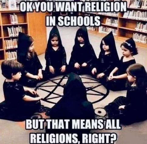 A meme addressing the debate over religion in public schools, set against the background of a school library. The image shows a group of young children dressed in black hooded robes sitting in a circle on the floor around a large pentagram. Large white impact font text at the top reads, "OK YOU WANT RELIGION IN SCHOOLS", and the text at the bottom concludes, "BUT THAT MEANS ALL RELIGIONS, RIGHT?".