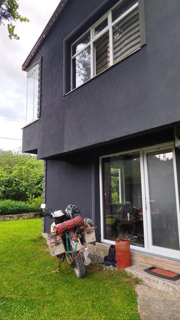 Motorrad auf Wiese vor Haus