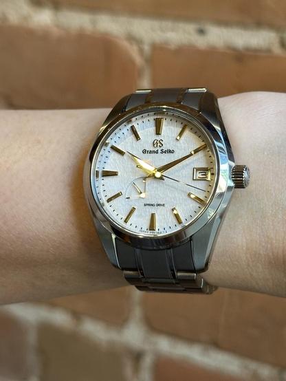 Wrist shot of a GS SBGA259 with hands and markers reflecting a specular golden hue.