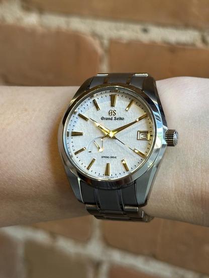 Wrist shot of a GS SBGA259 with hands and markers reflecting a specular golden hue.