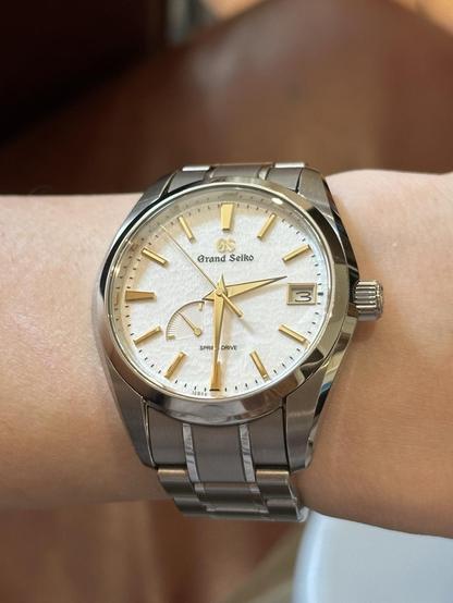 Wrist shot of a GS SBGA259 with hands and markers reflecting a diffused yellow hue.