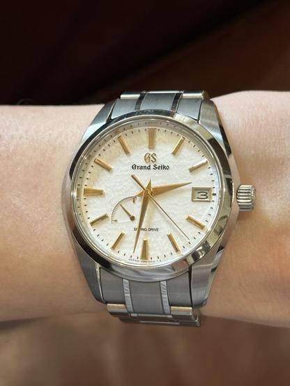 Wrist shot of a GS SBGA259 with hands and markers reflecting a diffused yellow hue.