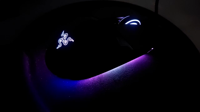 A mouse with multi-coloured led lighting on the underside, on which a trans flag is scrolling across.