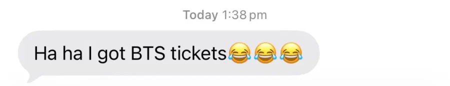 iPhone message reading "Ha ha I got BTS tickets 😂😂😂".