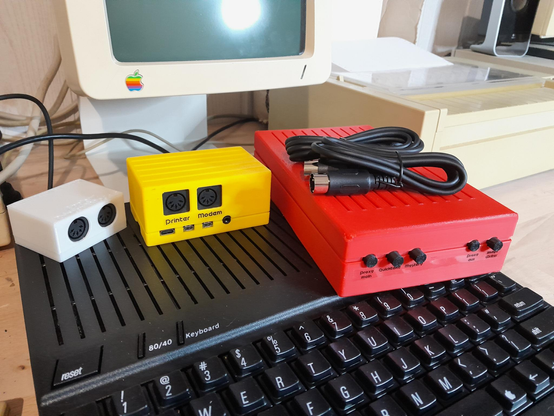 My three serial devices for the Apple II, from left to right:
- a white Quicktake Connector Box for digital photography
- a yellow Apple II Serial Hat for internet-enabled programs (Wozamp, Mastodon etc)
- a large red "CISD", with buttons in the front, to choose where to route the serial signals: to the proxy, the Quicktake, a third device of your choice, the proxy again on the other channel, and an ImageWriter.
