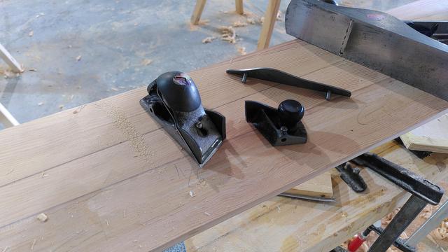 A Stanley 140 block plane in three parts on a big wooden workpiece. It dropped and the cast iron body snapped at the mouth.