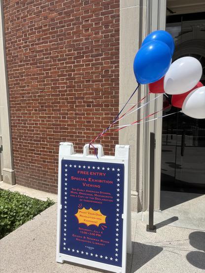 Sign with balloons outside the library.
