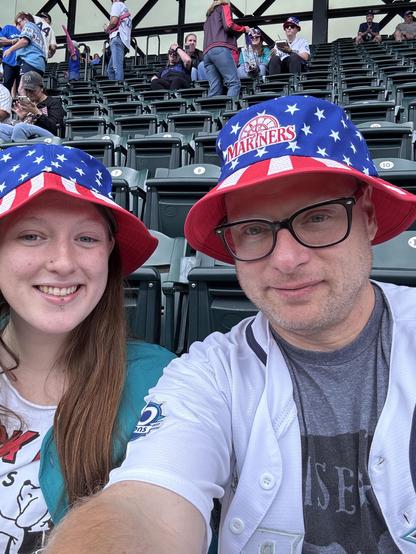 Girl on left, man on the right. Both are wearing America Stars and Stripes bucket hats
