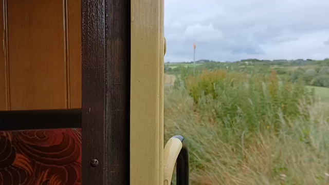 video shot from moving old train carriage running through grassy countryside