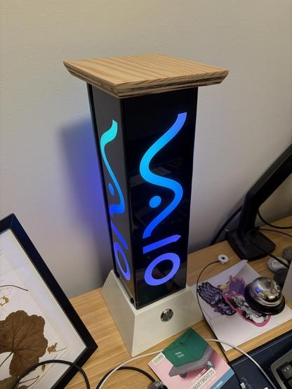 Photograph of the Vaio lamp showing it fully assembled with the plain wood lid. It's glowing various shades of blue.
