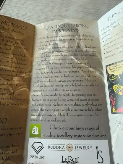 Piercing aftercare brochure. The background is that image of MCU!Loki sitting on the High Seat.