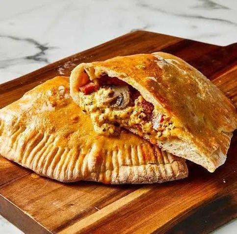 a calzone: a little pizza folded in half and closed like an empanada or a turnover, then baked or fried (napolitano style), seen here cut in half showing a filling of cheese, tomato, mushrooms, and salame (what americans erroneously call pepperoni)