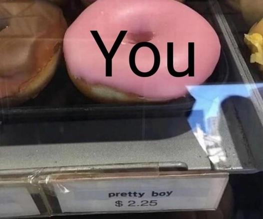 Pink donut on a shelf with the text "you" written on it. Underneath is the price tag with "pretty boy $2.25."
